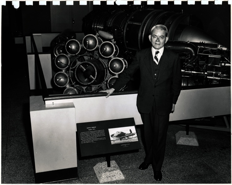 Frank Whittle with his first jet engine on display in a museum.