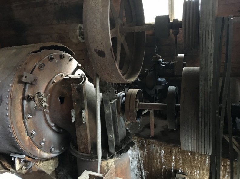 View of water wheel turbine on left and the governor in the back ground.