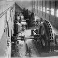Elevated view of a man standing near the governors and generators inside the Prairie du Sac power house in 1915.