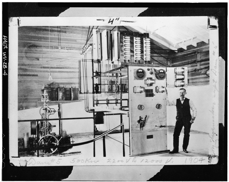 Photocopy_of_photograph,_c._1904._INTERIOR_OF_ORIGINAL_POWER_HOUSE,_SHOWING_M.P.C._SUPERINTENDENT_H._B._SHOEMAKER_BESIDE_SWITCH._AT_LEFT_IS_A_REPLOGLE_RELAY_WATER_WHEEL_GOVERNOR_HAER_WVA,2-HEDVI.V,1-4.tif.jpg