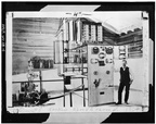 Power house at dam #5, circa 1904. INTERIOR OF ORIGINAL POWER HOUSE, SHOWING M.P.C. SUPERINTENDENT H. B. SHOEMAKER BESIDE SWITCH. AT LEFT IS A REPLOGLE RELAY WATER WHEEL GOVERNOR HAER WVA,2-HEDVI.V,1-4.tif