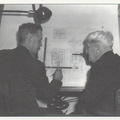 George Sorenson and Elmer Woodward looking over a diesel engine governor drawing.