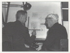 George Sorenson and Elmer Woodward looking over a diesel engine governor drawing.