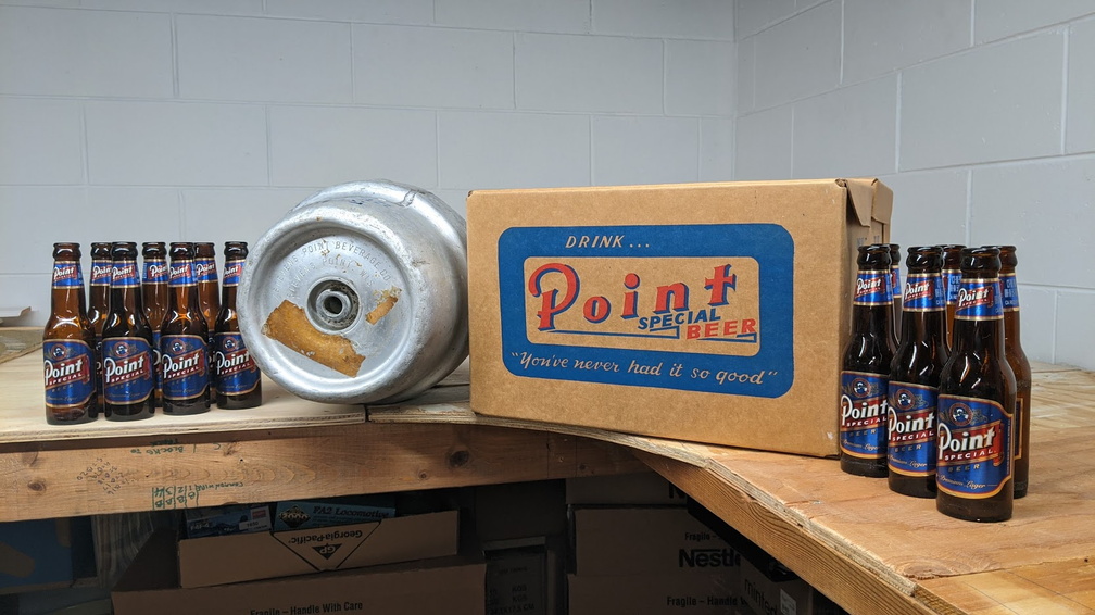 Vintage 7oz Point Special Lager bottles(case full) next to a Point beer pony keg next to a case of 32 oz bottles.