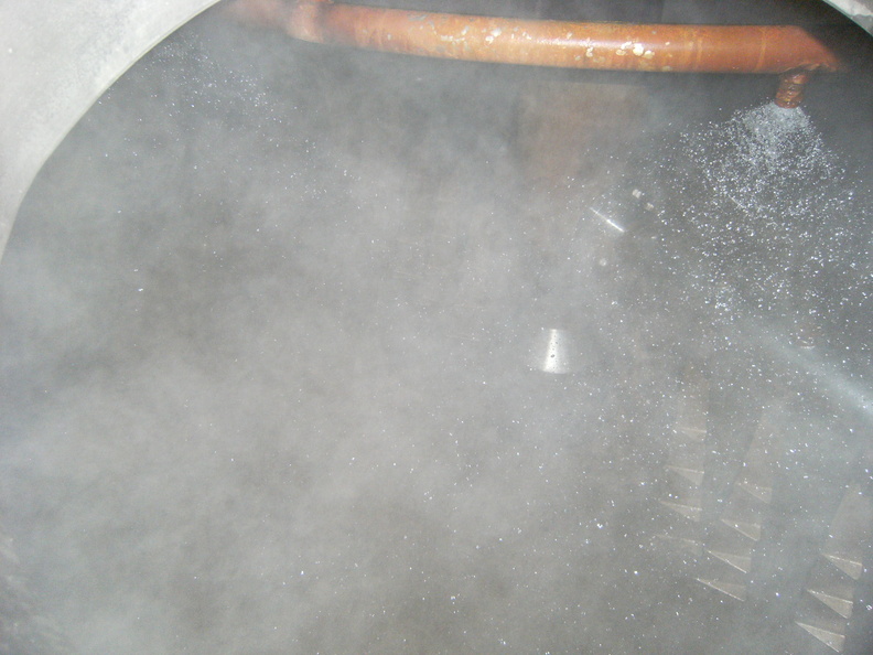 Cleaning out the spent grain while boiling the wort in the other brew kettle.