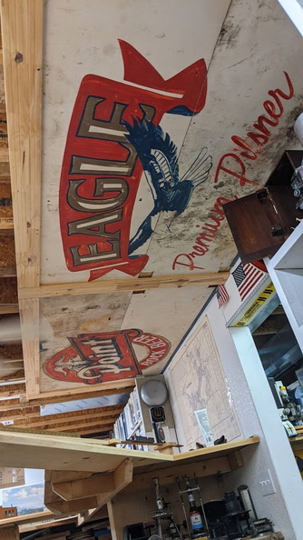 Old beer signs made into brewery garage shelving repurposed into ceiling art.