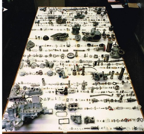 A jet engine fuel control governor unit disassembled and all the components on display.