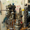 An AiResearch small gas turbine fuel control surrounded by scrap gas turbine governor components and tooling.  4.