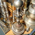An AiResearch small gas turbine fuel control surrounded by whimsical gas turbine fuel control parts and tooling.