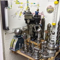 An AiResearch small gas turbine fuel control surrounded by scrap gas turbine governor components and tooling.  2.