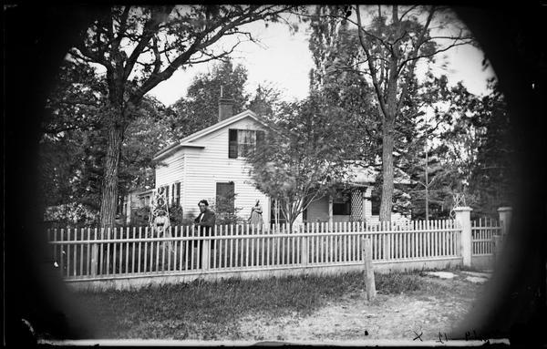1867 view of a Family behind a picket fence in front of thei.jpg