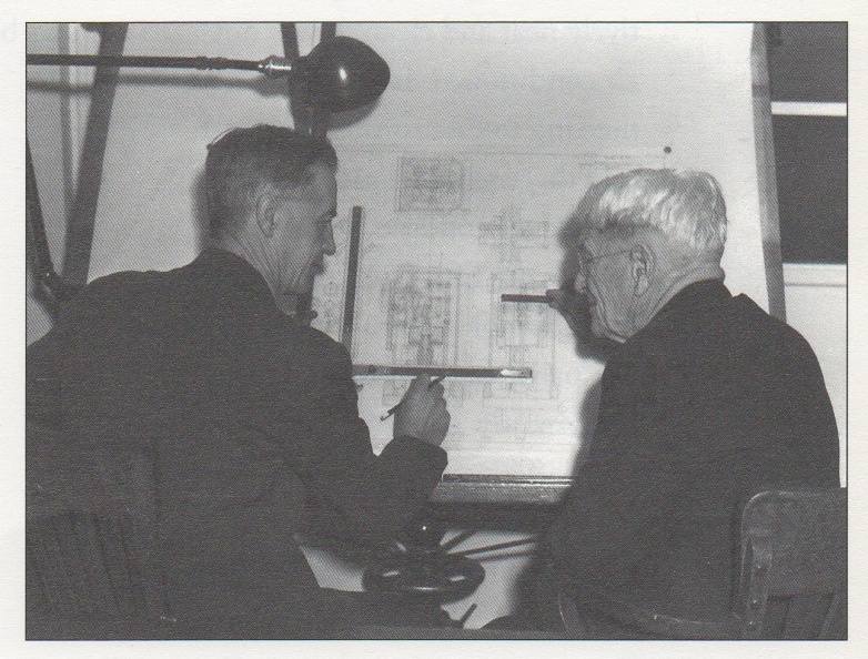 George Sorenson and Elmer Woodward discussing a drawing of Elmer's 1932 diesel engine governor.